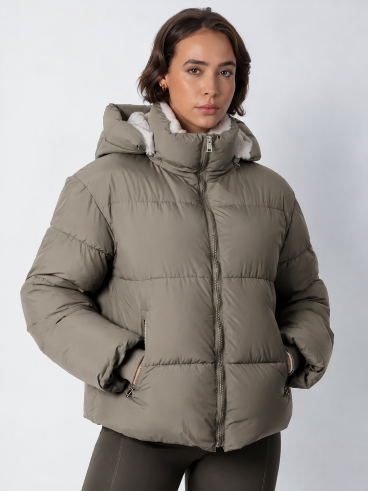 Veste taupe zippée jusqu'au col, capuche posée, mannequin de face aux mains dans les poches 18