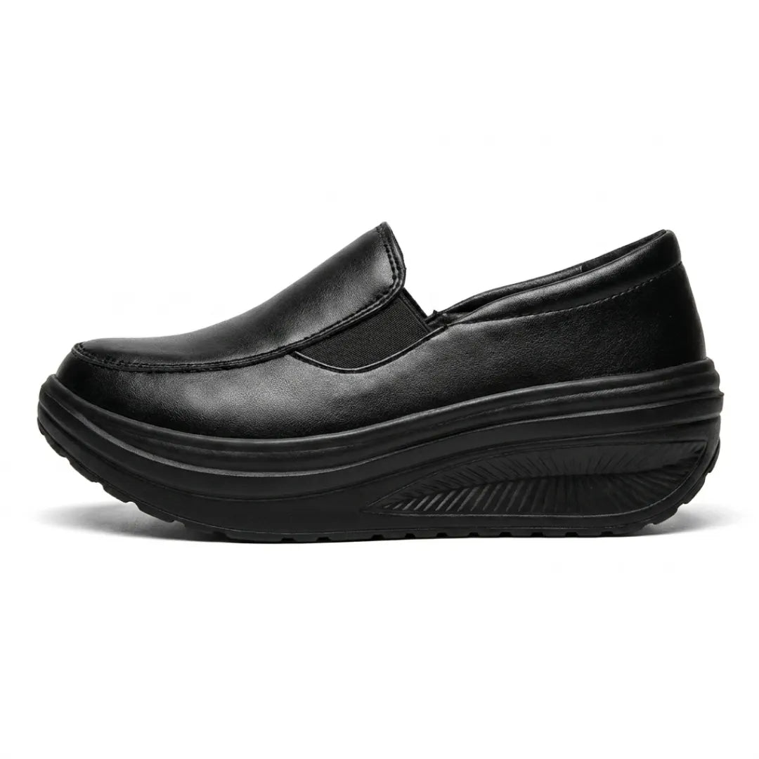 Mocassin noir vu de profil, avec empiècement élastique et épaisse semelle compensée ondulée 1
