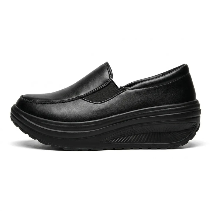 Mocassin noir vu de profil, avec empiècement élastique et épaisse semelle compensée ondulée 1