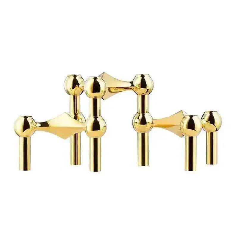 Trois modules de porte-bougie en métal doré brillant, aux têtes sphériques, posés séparément sur fond blanc. 1