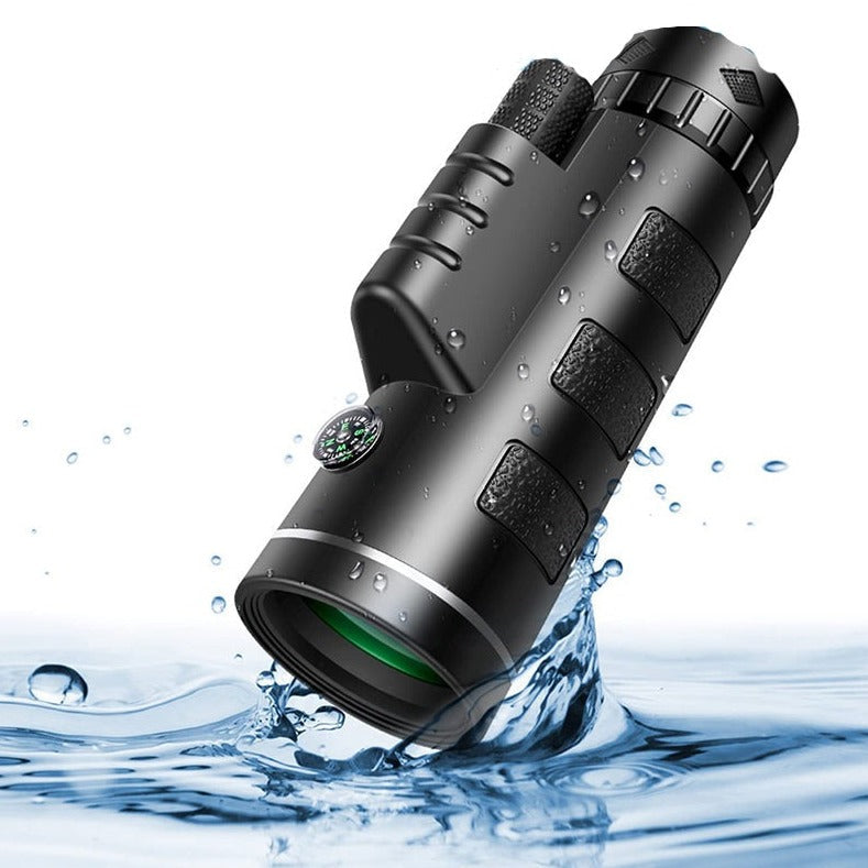 Monoculaire noir éclaboussé par l'eau, avec boussole intégrée et surfaces antidérapantes, illustrant sa résistance aux projections. 2