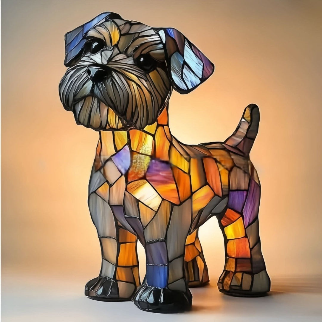 Veilleuse en forme de petit chien à poils broussailleux, tête penchée, aspect vitrail aux teintes orangées, violettes et bleues, allumée sur fond chaud. 21