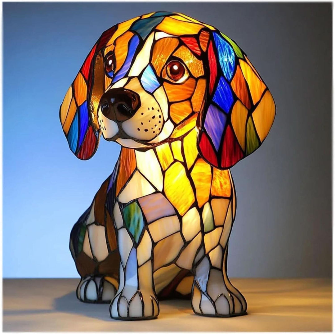 Veilleuse en forme de beagle assis, aux tesselles façon vitrail orange, blanc, bleu et rouge, allumée sur fond bleu. 1