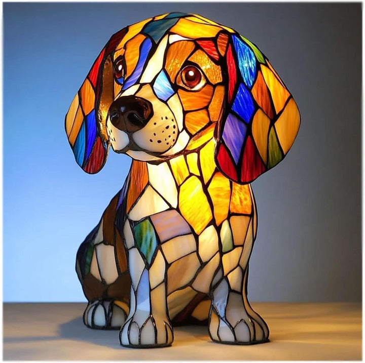 Veilleuse en forme de beagle assis, aux tesselles façon vitrail orange, blanc, bleu et rouge, allumée sur fond bleu. 1