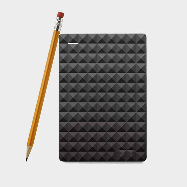 Disque noir posé à côté d'un crayon en bois pour montrer sa taille compacte 8