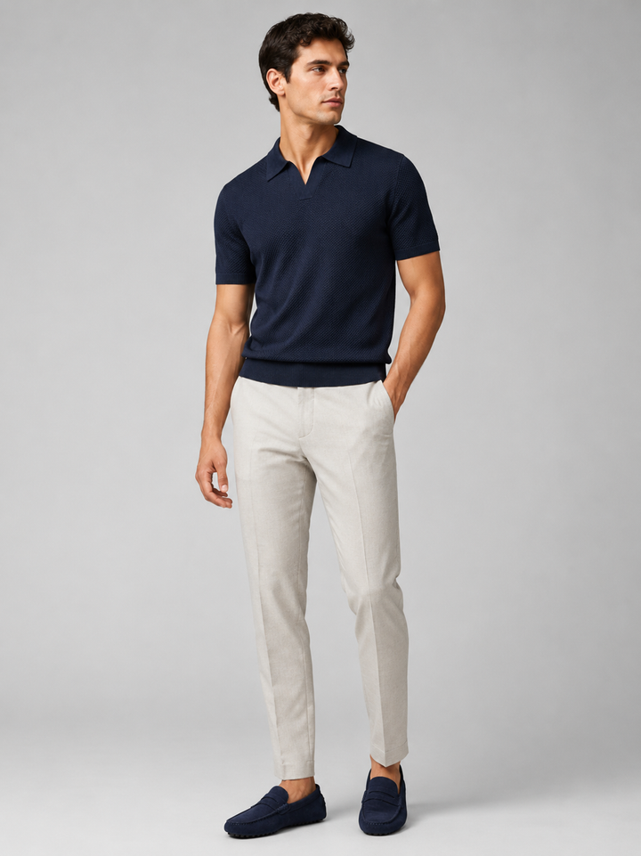 Homme en pied portant le polo bleu marine avec pantalon clair et mocassins bleu marine, vue de face 37