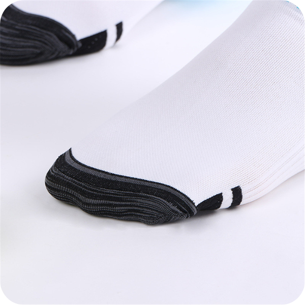 Gros plan sur le bout renforcé gris foncé d'une chaussette blanche, avec deux fines bandes noires. 4