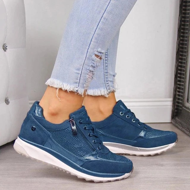 Baskets bleu marine à lacets et zip latéral portées avec un jean clair effiloché, empiècements brillants et semelle blanche. 5