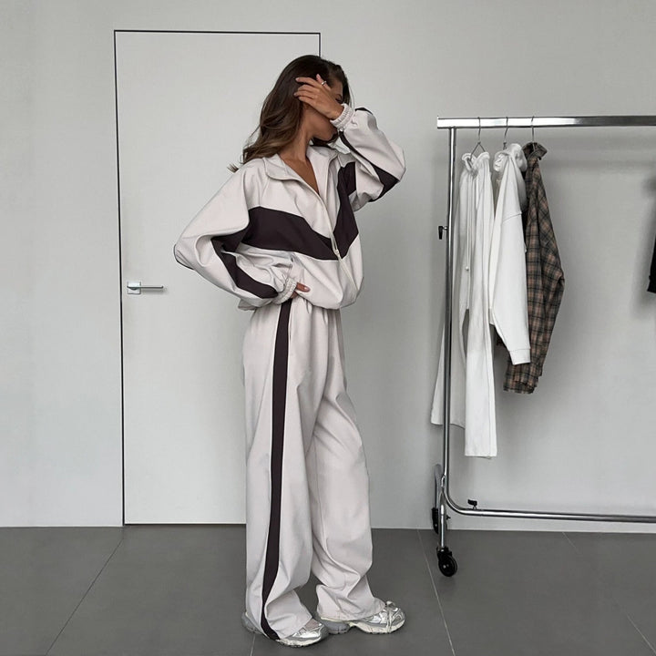 Vue de profil de l'ensemble beige à bandes foncées en chevron, veste zippée aux poignets élastiques et pantalon large à bande latérale. 3