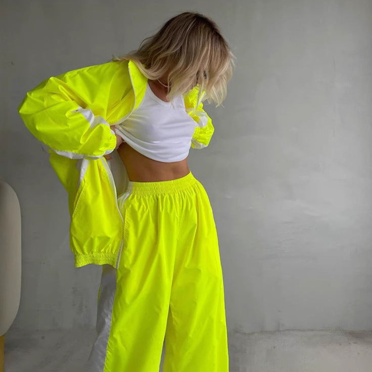 Ensemble jaune fluo avec veste zippée ouverte sur un haut blanc et pantalon large à taille élastique, modèle penchée en avant. 6