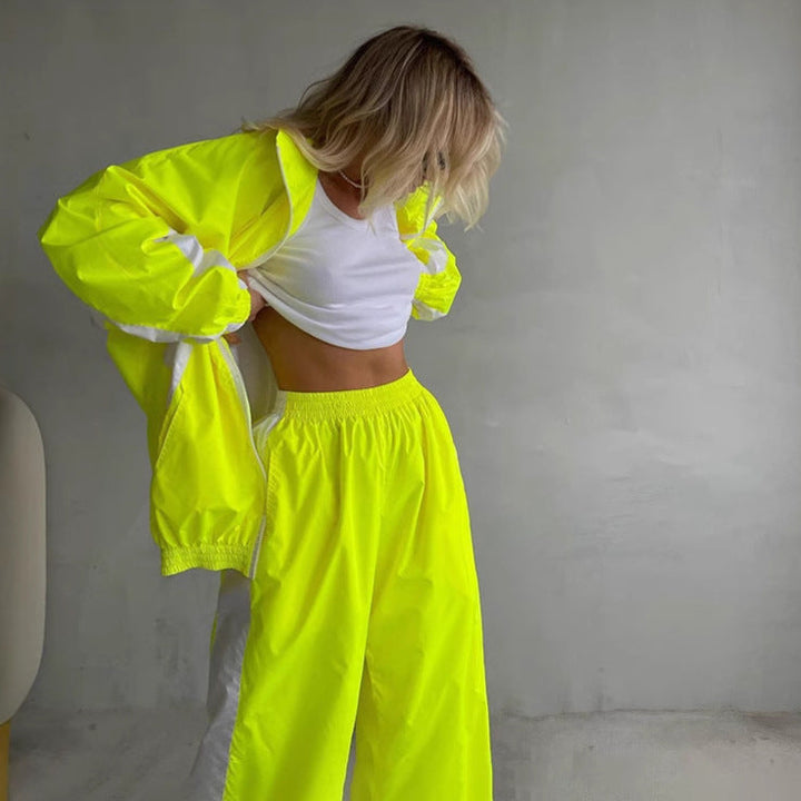 Ensemble jaune fluo avec veste zippée ouverte sur un haut blanc et pantalon large à taille élastique, modèle penchée en avant. 6