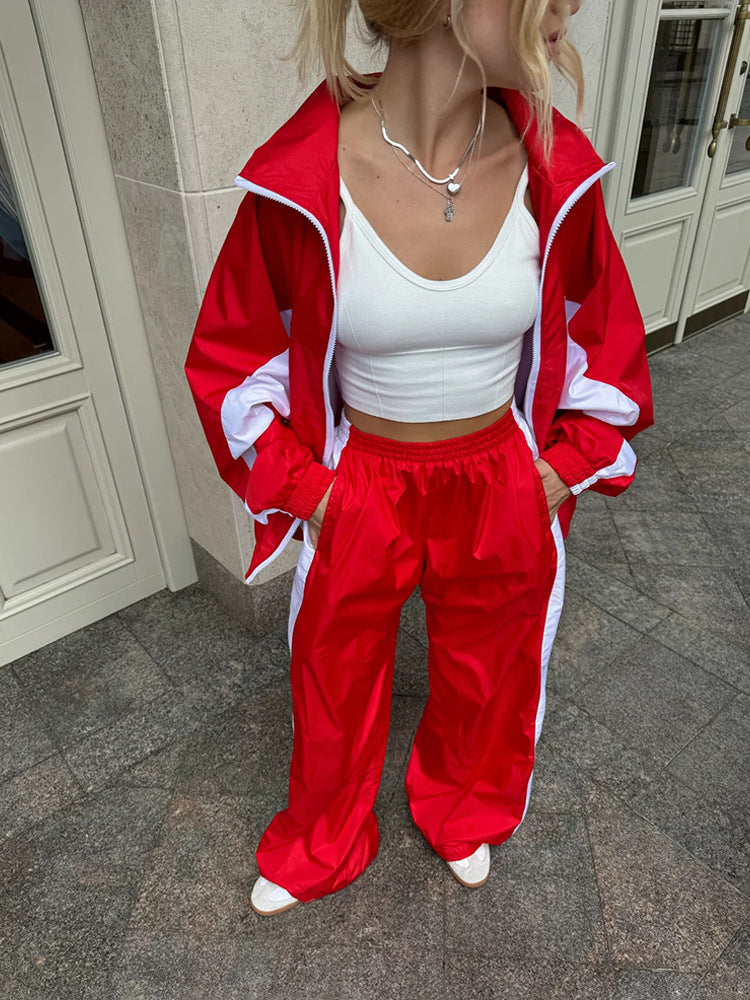 Plan de la taille aux pieds d'un ensemble rouge à bandes blanches, veste ouverte, pantalon large à taille élastique, mains dans les poches. 17