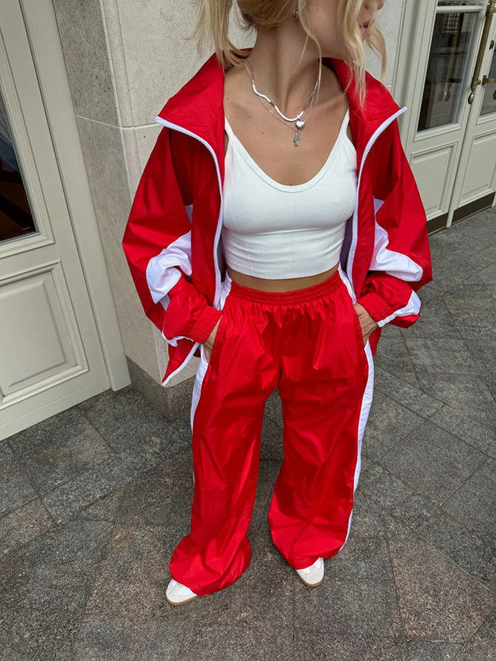 Plan de la taille aux pieds d'un ensemble rouge à bandes blanches, veste ouverte, pantalon large à taille élastique, mains dans les poches. 17