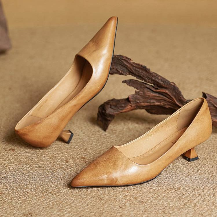 Paire d'escarpins caramel posée sur un tapis, un pied incliné près d'un morceau de bois 5