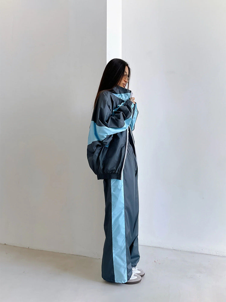 Vue de profil d'un ensemble bleu foncé à bandes bleu clair, veste zippée ample et pantalon large à bande latérale. 13