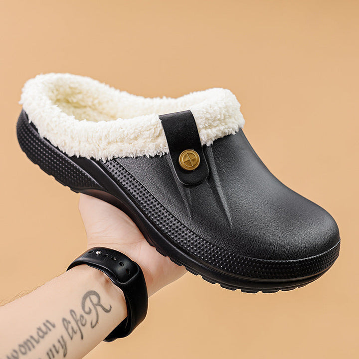 Sabot noir à doublure de fausse fourrure blanc crème tenu à la main sur fond beige 12