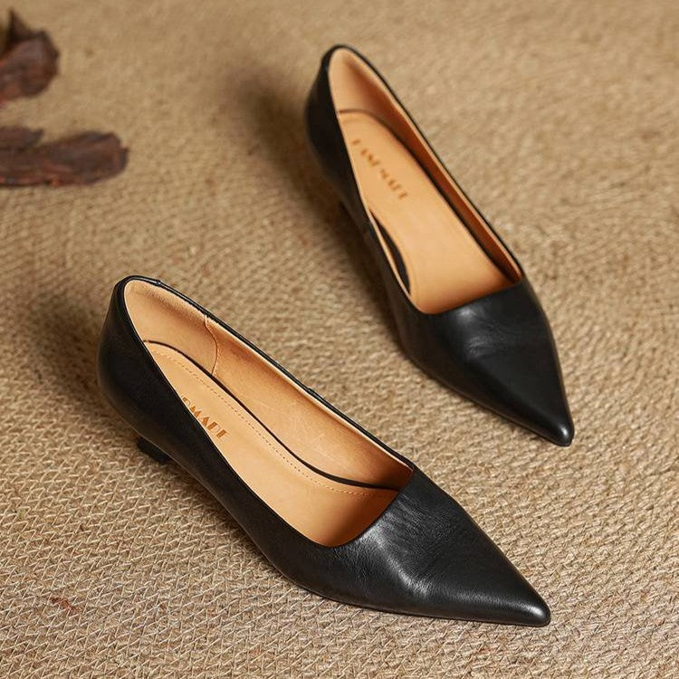 Paire d'escarpins noirs posée sur un tapis tressé, intérieur en cuir clair visible 16
