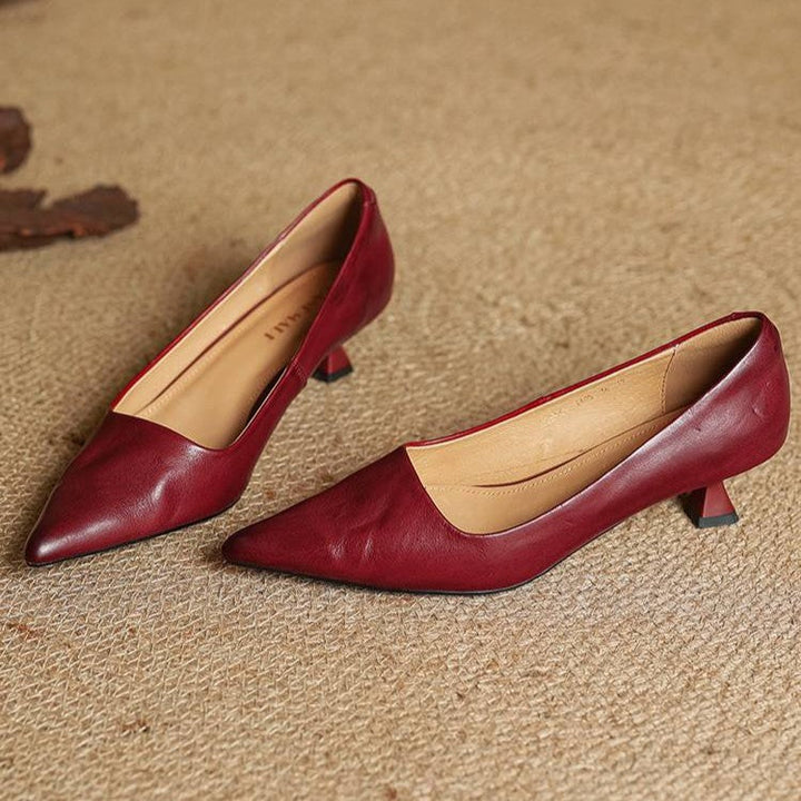 Paire d'escarpins rouge bordeaux posée sur un tapis tressé, doublure beige visible 11
