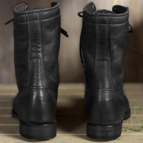 Vue de dos d'une paire de bottes noires en cuir, avec coutures verticales sur le talon et semelle plate à petit talon. 4