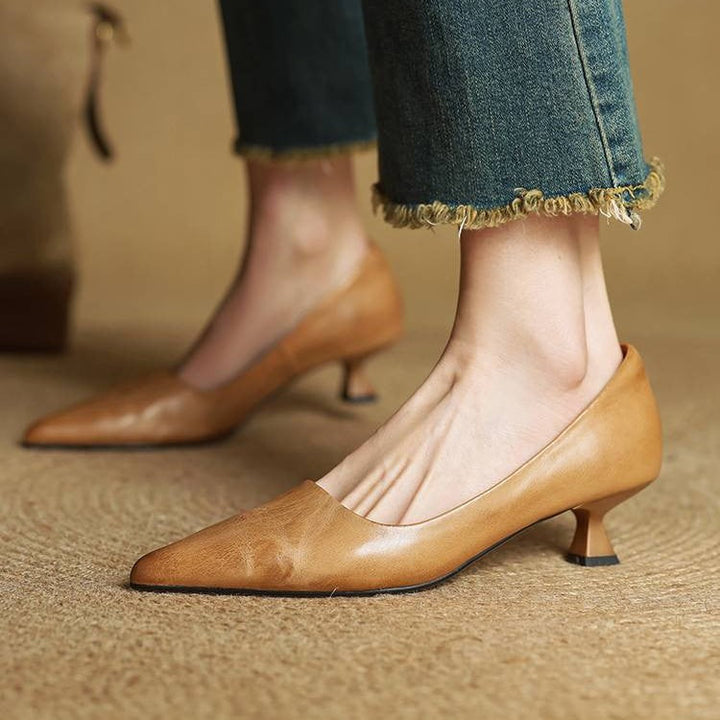 Escarpins caramel portés avec un jean effiloché, vue de côté sur un tapis tressé 2