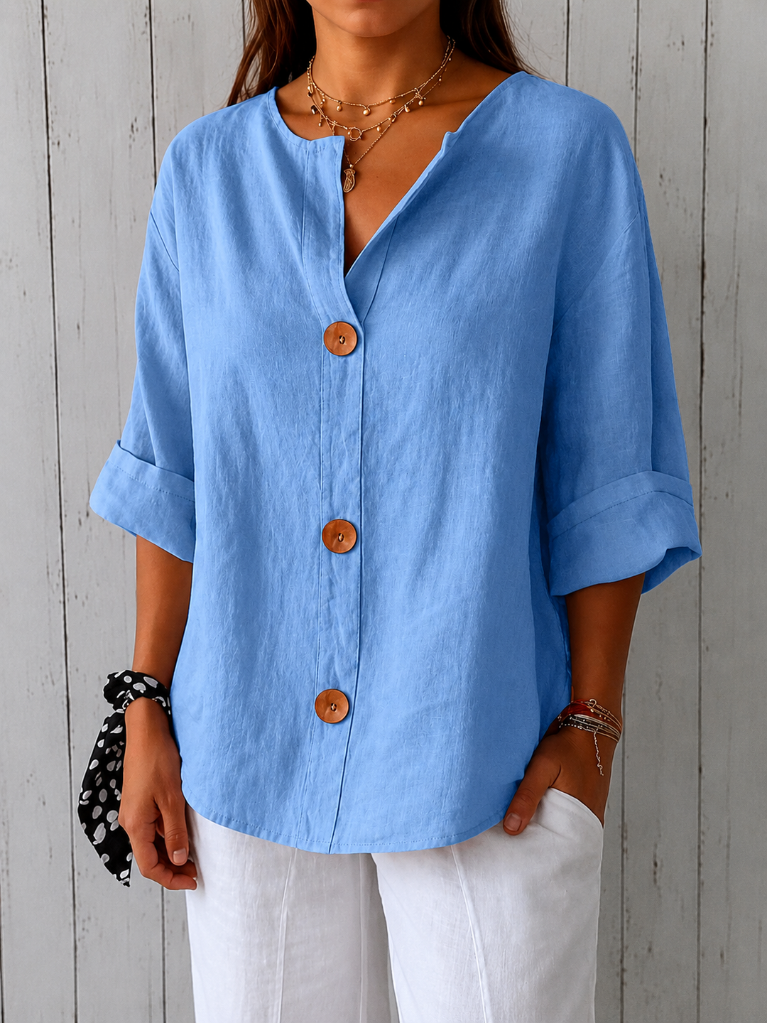 Blouse bleu ciel photographiée en plan plus large et plus net, tissu lin texturé, ourlet arrondi, pantalon blanc et chouchou à pois. 13