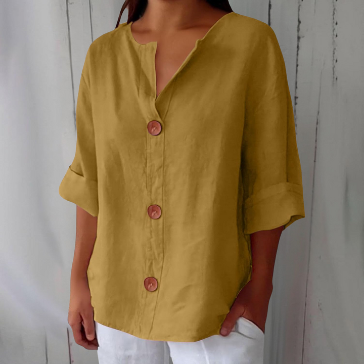 Même blouse en jaune moutarde, plan resserré sur le buste d'une mannequin, boutons en bois et manches retroussées. 6