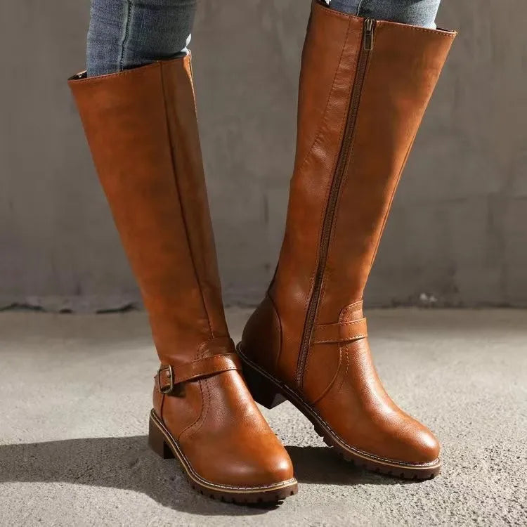 Bottes hautes camel portées avec un jean, vues de côté avec la fermeture éclair et la boucle sur la cheville. 1