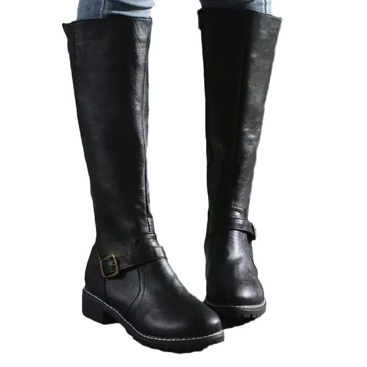 Bottes hautes noires sur fond blanc, portées avec un jean, montrant la boucle de cheville et la semelle épaisse. 5