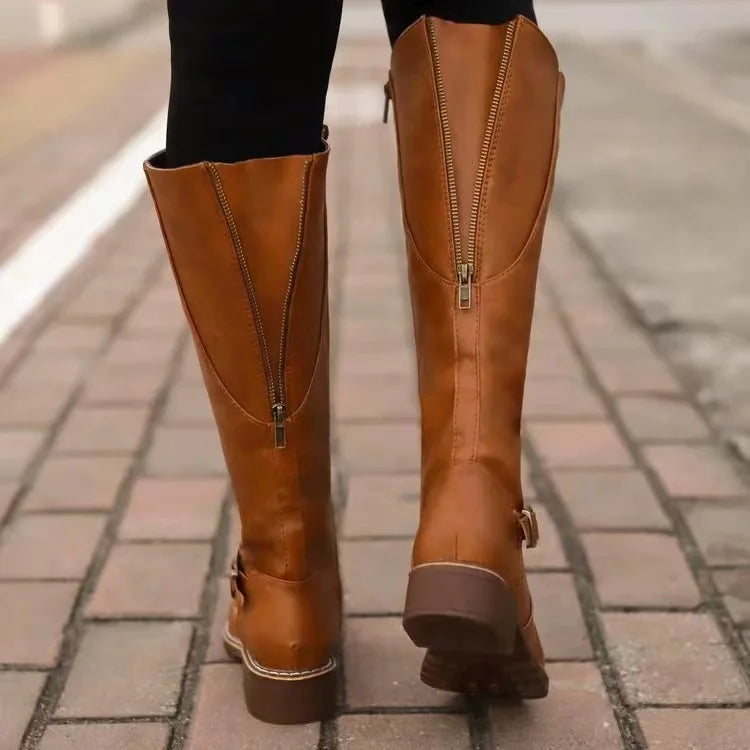 Bottes camel vues de dos sur un trottoir pavé, avec la fermeture éclair centrale qui monte sur la tige. 6
