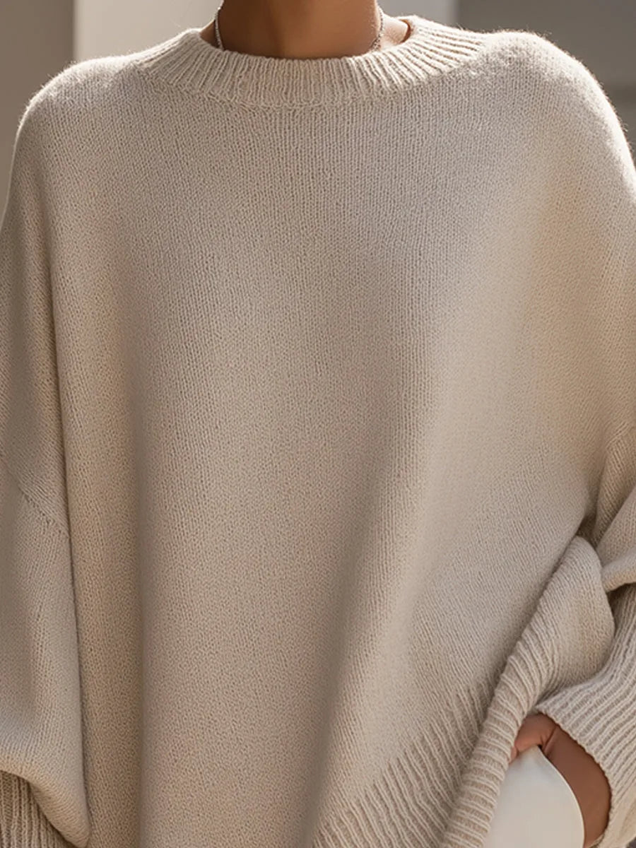 Gros plan sur l'encolure ronde côtelée et la maille fine du pull beige, porté par un modèle. 2