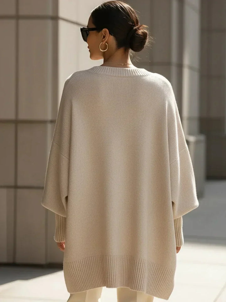 Pull beige oversize vu de dos sur une femme aux cheveux relevés, avec ourlet et poignets côtelés. 4