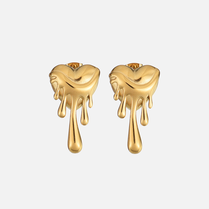 Paire de boucles d'oreilles en forme de cœur doré qui fond, vue de face sur fond clair, avec longues gouttes. 1