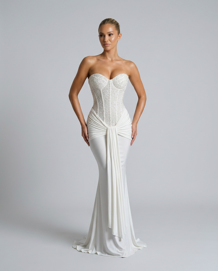 Robe blanche portée mains sur les hanches, coupe sirène, bustier perlé et drapé qui souligne la taille 8