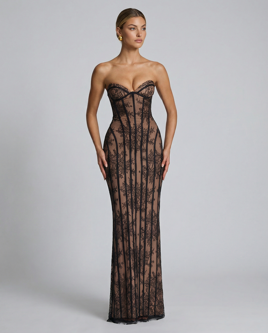 Robe noire en dentelle florale portée de face sur fond gris, buste en coeur et baleines verticales. 8