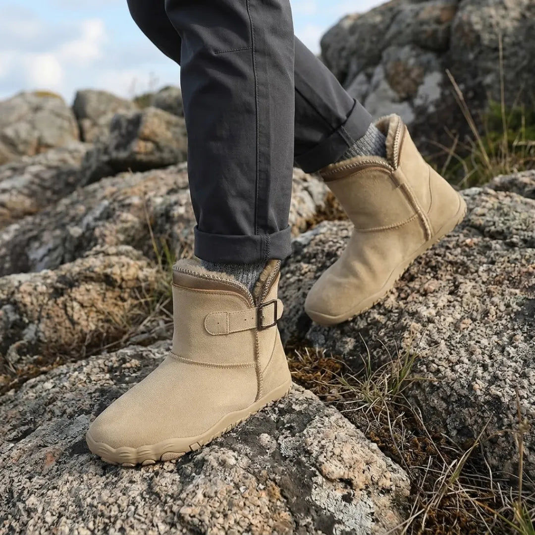 Bottes beiges portées sur des rochers, avec pantalon gris retroussé et chaussettes épaisses 2