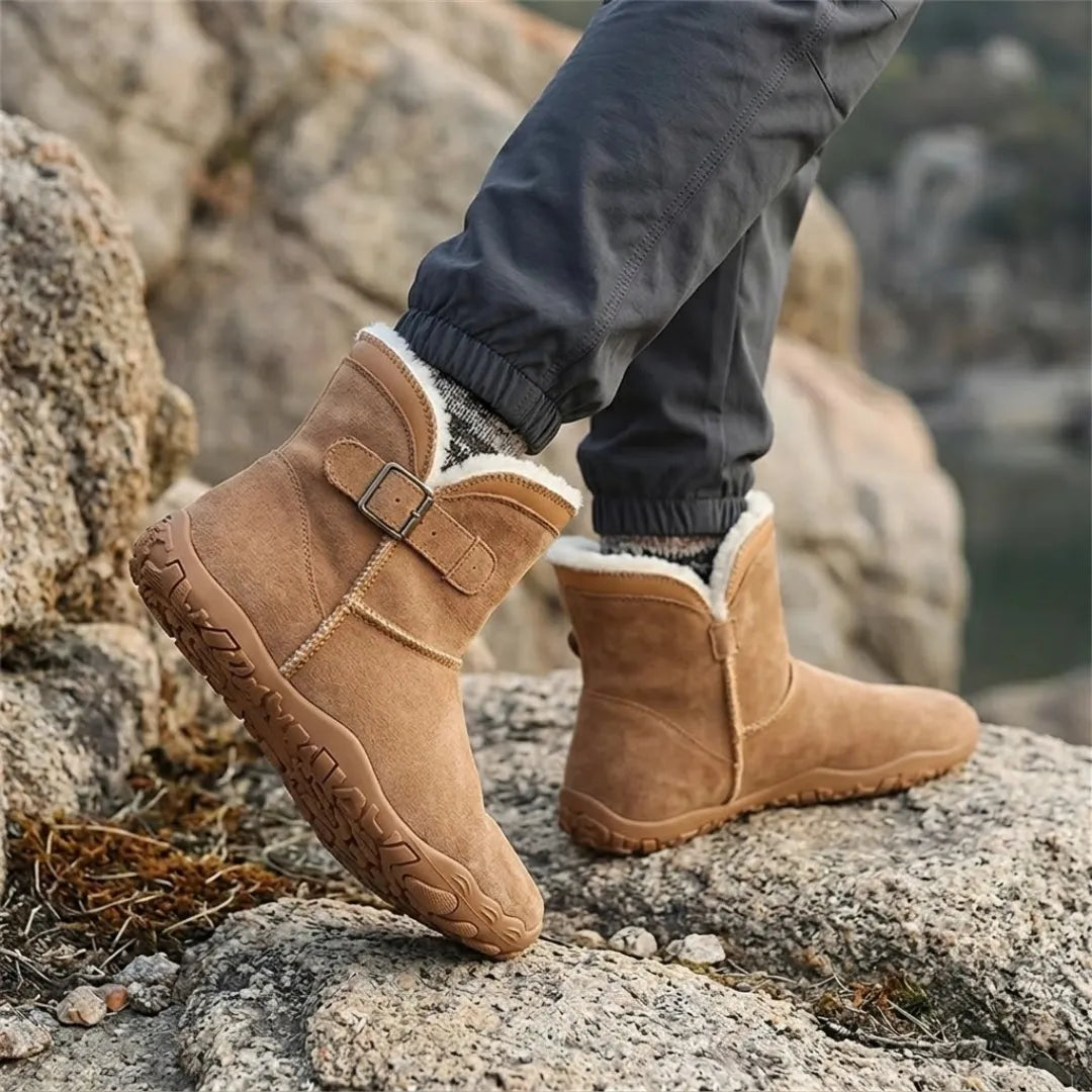 Bottes camel portées sur des rochers, avec pantalon gris, chaussettes en laine et doublure blanche visible 20
