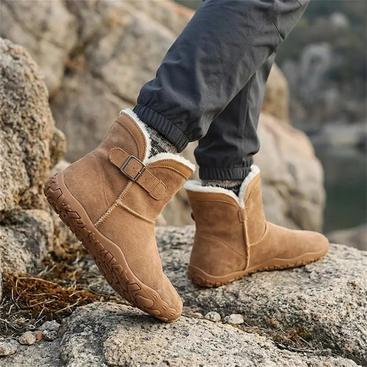 Bottes camel portées sur des rochers, avec pantalon gris, chaussettes en laine et doublure blanche visible 20