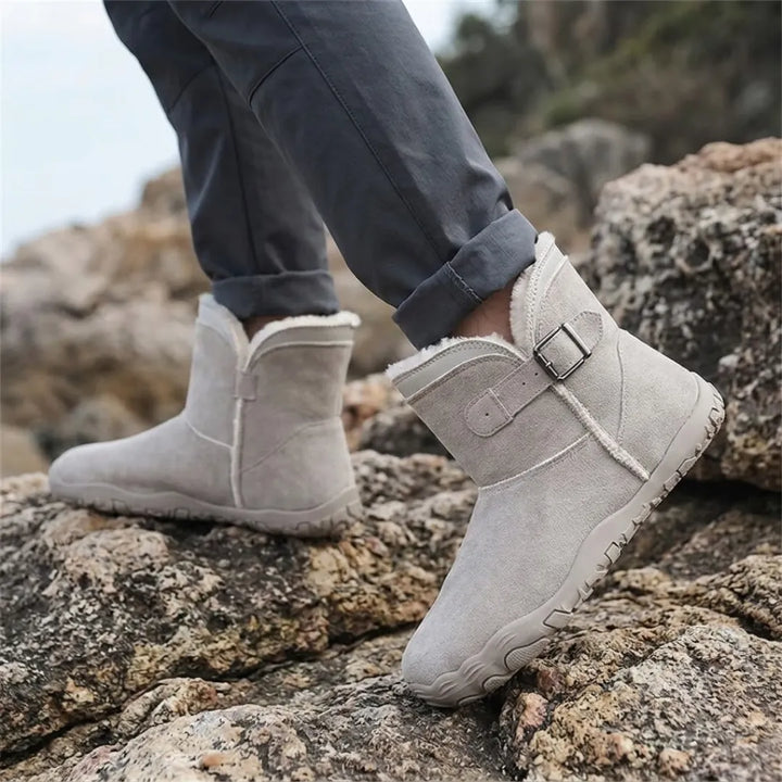 Pieds portant les bottes gris clair, pantalon retroussé, en marchant sur des rochers 29
