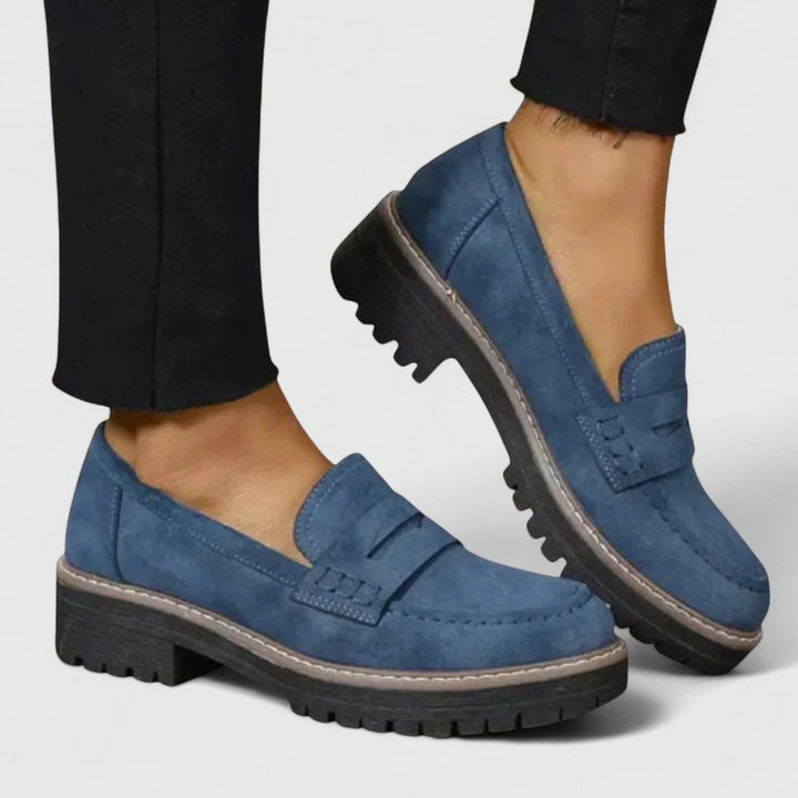Mocassins bleus portés avec un pantalon noir, l'un des pieds levé 4