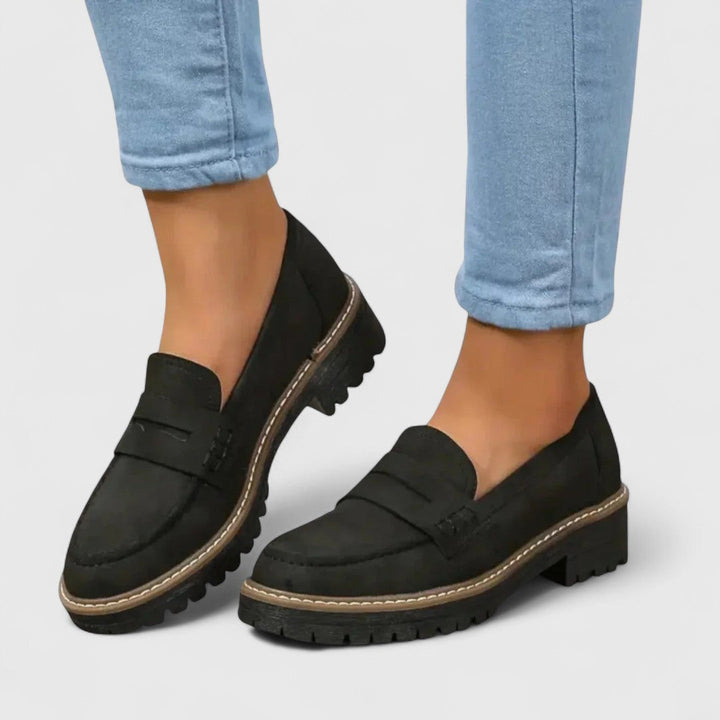 Mocassins noirs en aspect daim portés avec un jean bleu clair, vue de trois quarts 1