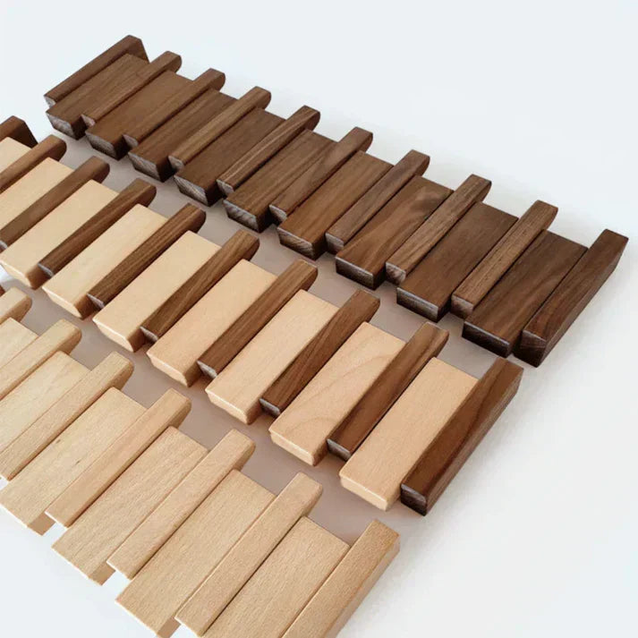 Pièces de bois en deux teintes, foncée et claire, disposées à plat sur une surface blanche avant l'assemblage. 3