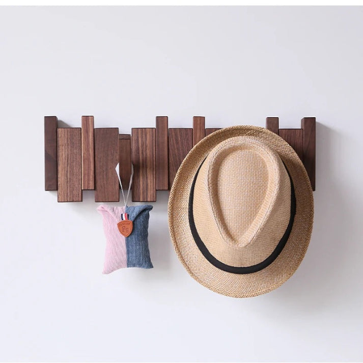 Porte-manteau en bois foncé portant un chapeau de paille et un petit sac rose et bleu suspendu. 5
