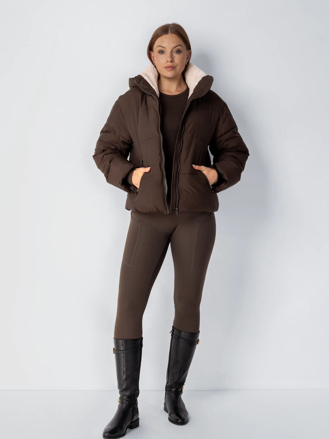 Mannequin en pied portant la veste marron ouverte, legging assorti et bottes hautes noires 15