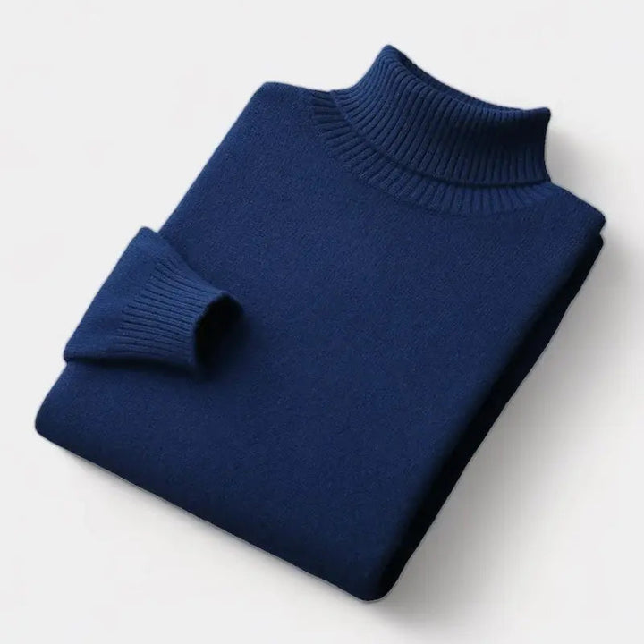 Pull à col roulé bleu marine plié à plat, manche repliée sur le devant 7