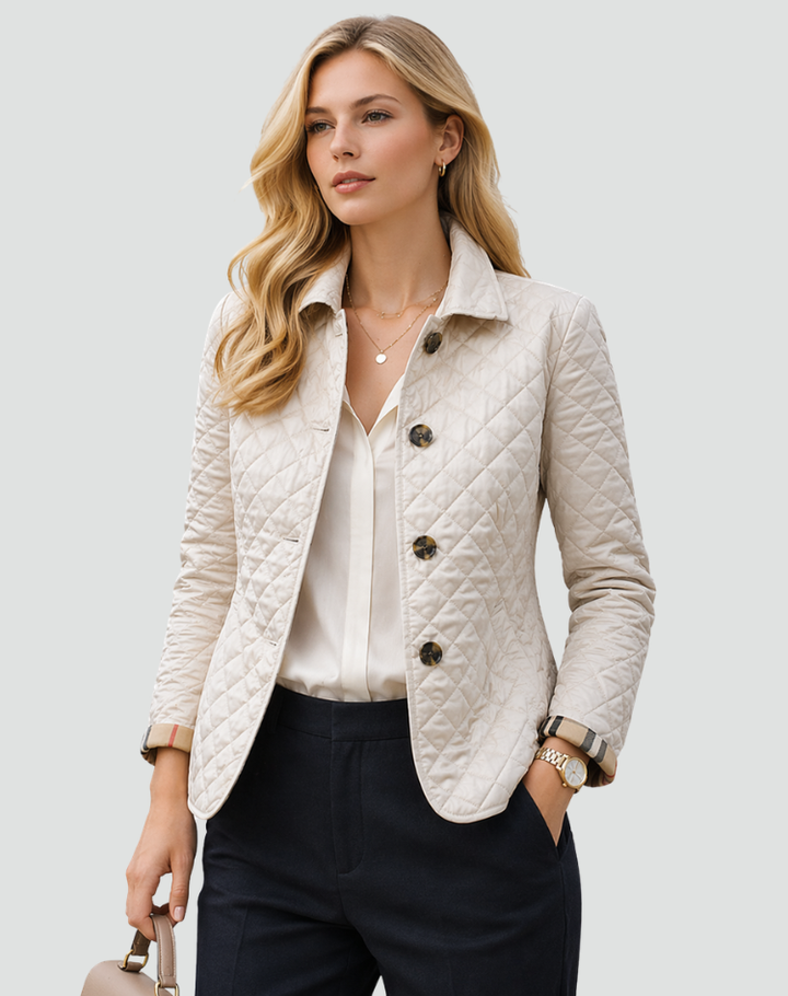 Veste matelassée beige clair portée avec chemisier crème et pantalon sombre, sac à main à la main, boutons écaille et poignets à carreaux. 2