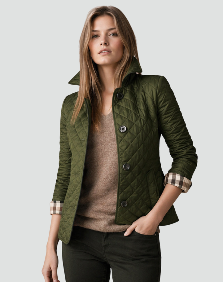Veste matelassée vert kaki portée sur un pull marron à col V et un pantalon sombre, une main dans la poche, manches retroussées. 9