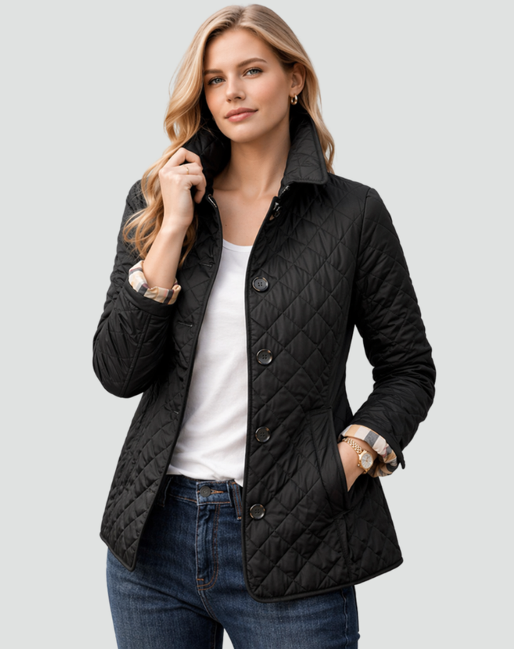 Veste matelassée noire portée par une mannequin avec t-shirt blanc et jean, une main dans la poche, manches retroussées sur doublure à carreaux. 1