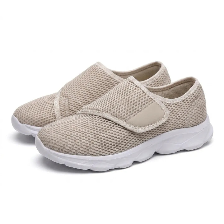 Paire de chaussures beiges en mesh aérée, sangle auto-agrippante sur le dessus et semelle blanche épaisse, vue de trois quarts sur fond blanc. 34