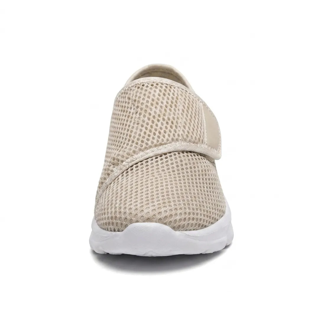 Vue de face d'une chaussure beige en mesh avec sangle auto-agrippante, montrant la largeur de l'empeigne et la semelle blanche. 35