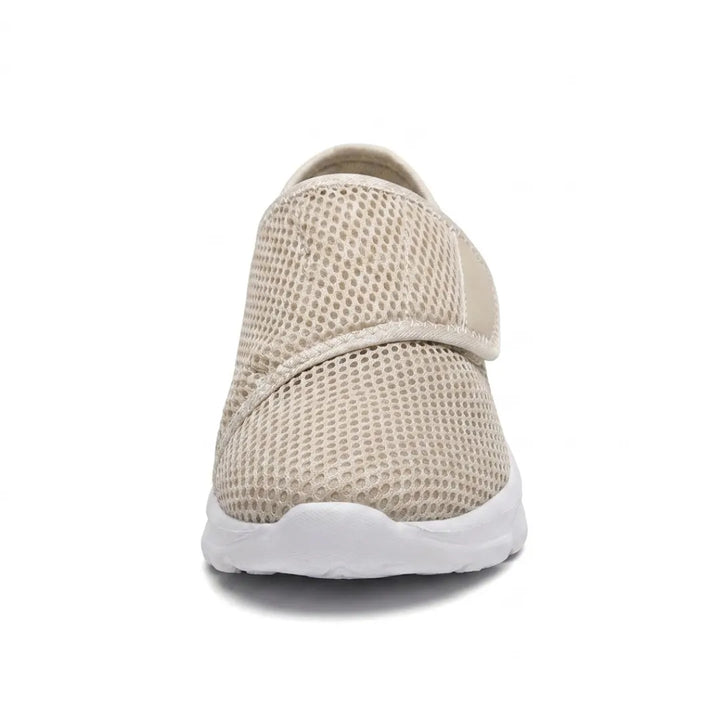 Vue de face d'une chaussure beige en mesh avec sangle auto-agrippante, montrant la largeur de l'empeigne et la semelle blanche. 35